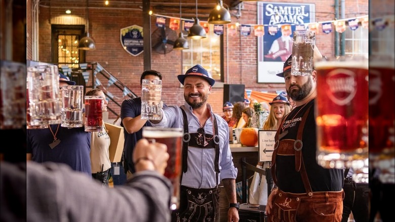 people holding up their beer steins at an Oktoberfest event