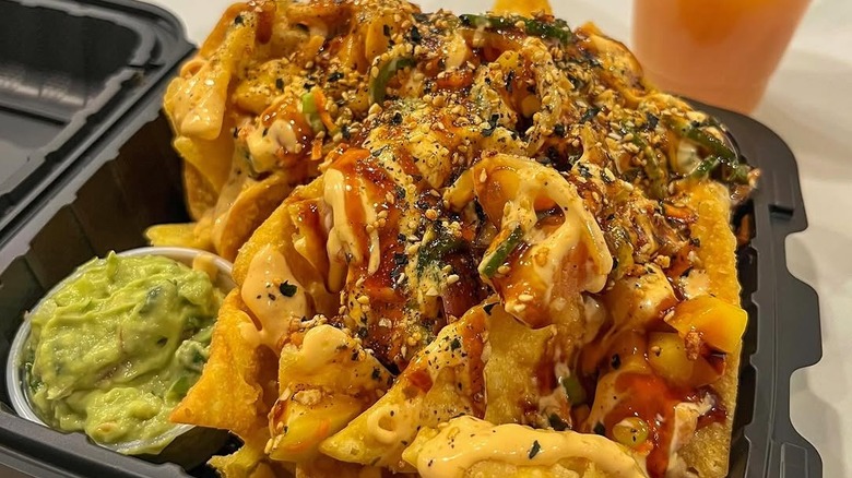 Nachos loaded with salmon poke with a side of guacamole