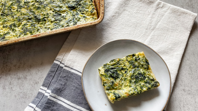 Spinach cottage cheese pie in baking dish and sliced onto plate