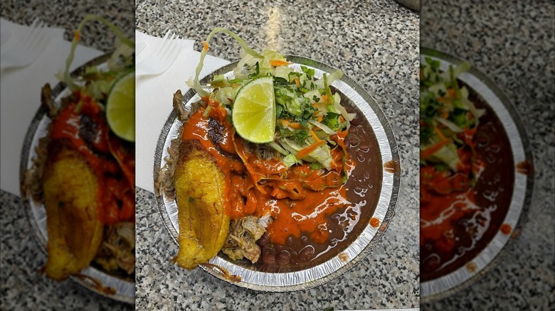 Plate of food with stewed meat, red beans, red sauce, and shredded greens from El Sabroso