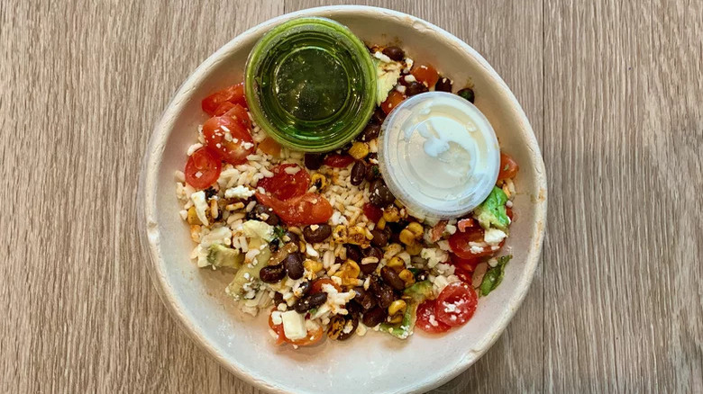 Top view of Panera's Baja bowl with sauces in plastic cups
