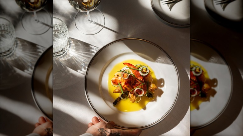 waiter placing dish on table at Le Coucou