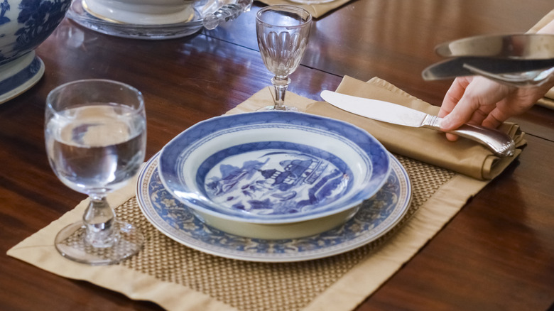 antique bowl and plate being set out for dinner with place setting