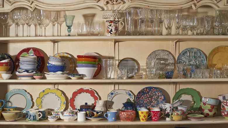 open shelving in kitchen full of colorful plates and glasses
