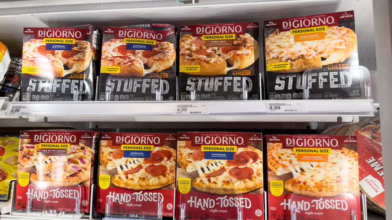 Several boxes of frozen DiGiorno pizzas on a store shelf.