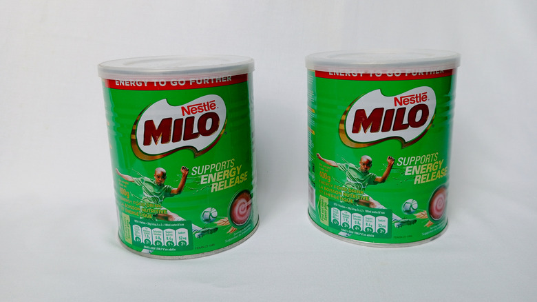 Two cans of Nestle's Milo chocolate energy powder.