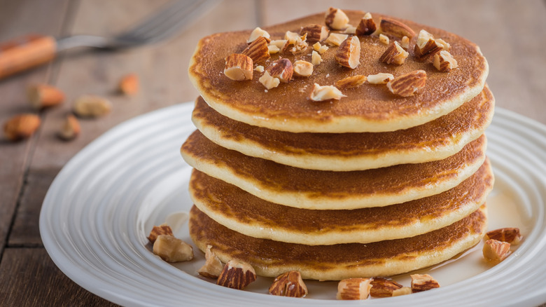 Stack of pancakes topped with chopped almonds