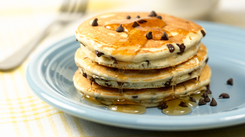 Stack of chocolate chip pancakes on blue plate