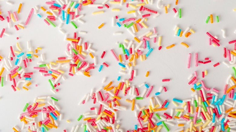 Rainbow candy sprinkles on white background
