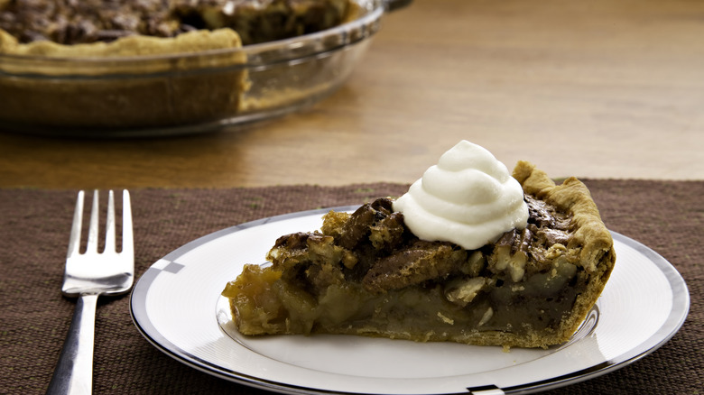 Pecan pie topped with whipped cream