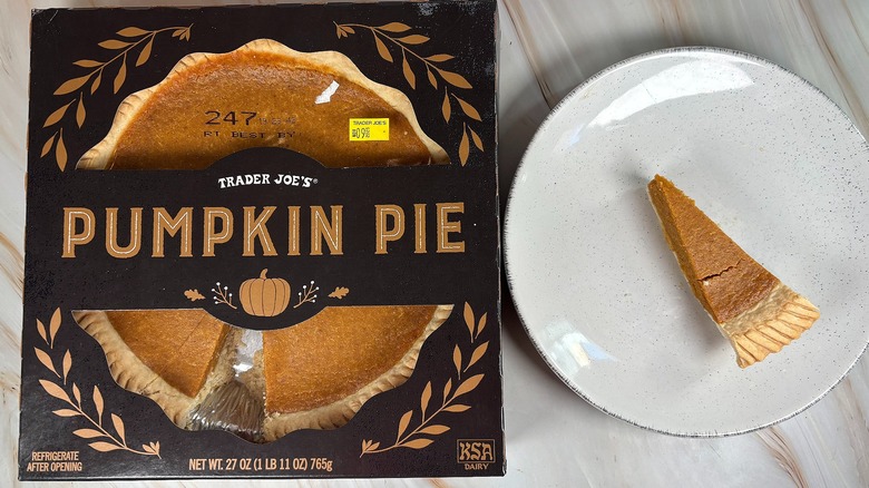 Trader Joe's Pumpkin Pie slice next to packaging on marbled surface