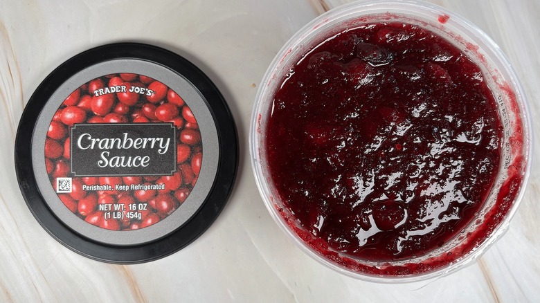 Trader Joe's Cranberry Sauce next to lid on marbled surface