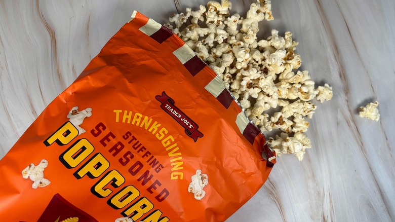 Trader Joe's Thanksgiving Stuffing Seasoned Popcorn spilling out of bag onto marbled surface