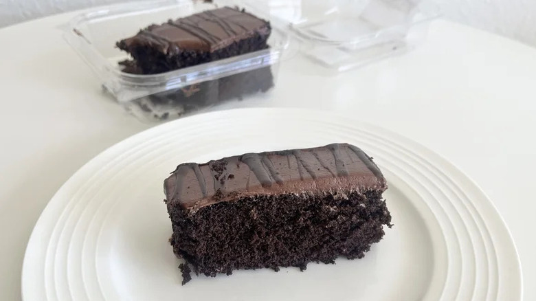 Chocolate cake slice from Walmart on a plate with more cake in the back