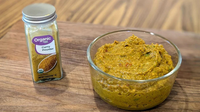 Great Value organic curry powder next to a bowl of yellow curry