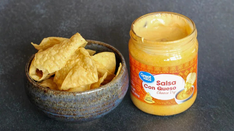 Jar of Great Value salsa con queso with chips on the side
