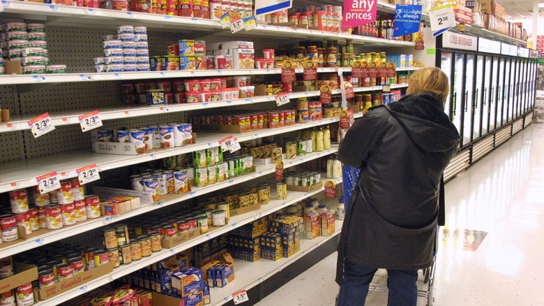 A person with back turned standing in a food aisle in Walmart