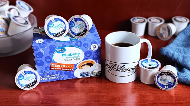 Great Value Blueberry coffee pod box, surrounded by loose pods and a mug of black coffee