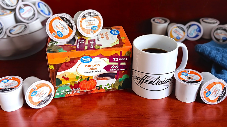 Great Value Pumpkin Spice coffee pod box, surrounded by loose pods and a mug of black coffee