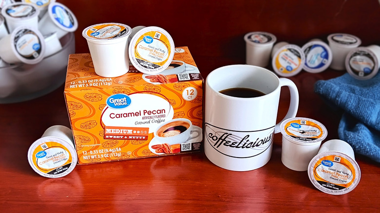Great Value Caramel Pecan coffee pod box, surrounded by loose pods and a mug of black coffee