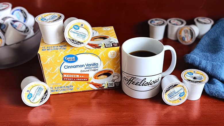 Great Value Cinnamon Vanilla coffee pod box, surrounded by loose pods and a mug of black coffee