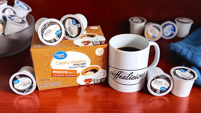 Great Value Creamy Hazelnut coffee pod box, surrounded by loose pods and a mug of black coffee