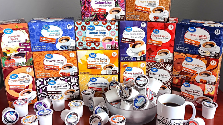 17 boxes of Great Value coffee pod varieties with a bowl of loose pods and mug of black coffee