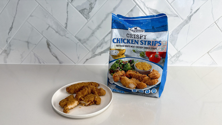Kirkwood crispy chicken strips on a plate with product bag alongside