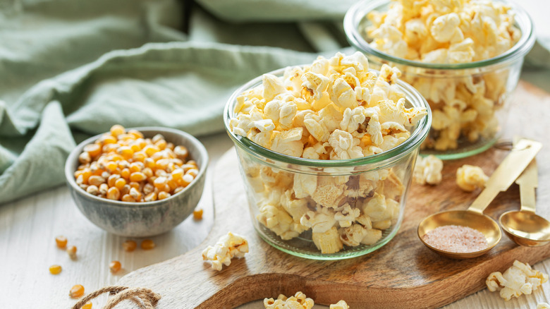 Bowl of homemade popcorn beside unpopped kernels