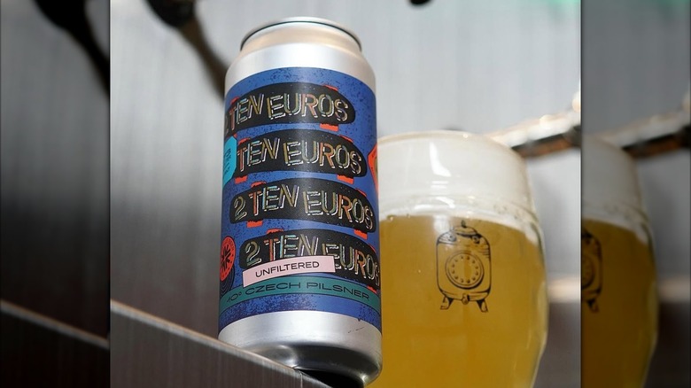 A can of 2 Ten Euros next to a full glass