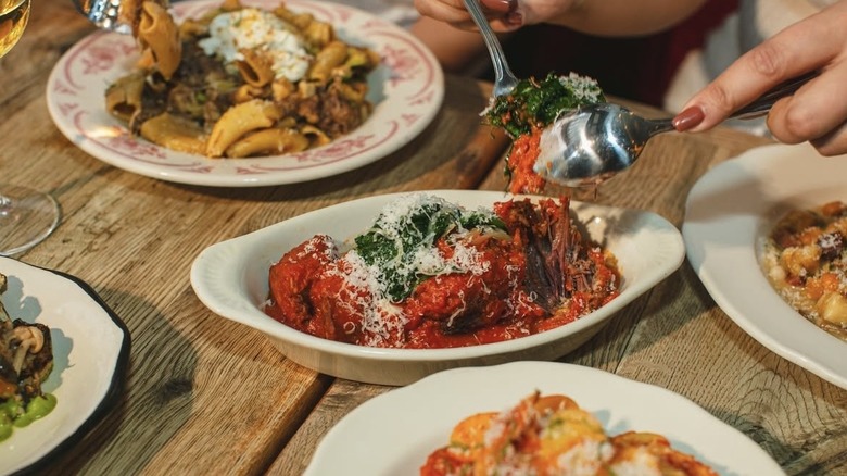 person using cutlery to grab meatball