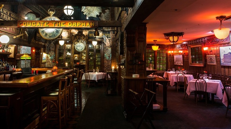 interior of Saloon showing white tablecloth-covered tables and warm lighting