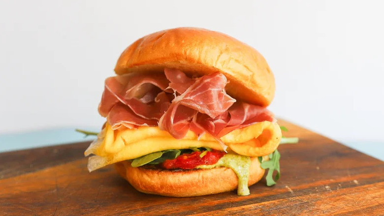 Pesto Prosciutto Breakfast Sandwich on wooden cutting board