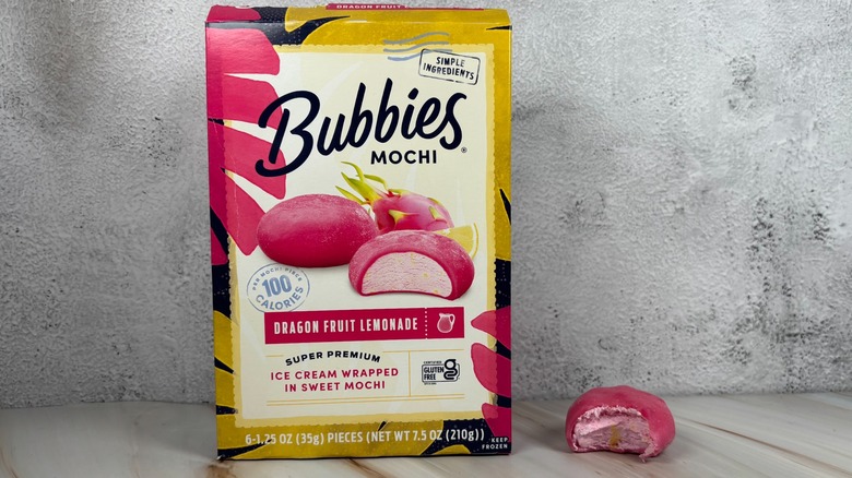 Bubbies Dragon Fruit Lemonade mochi box next to mochi with bite taken out of it on table