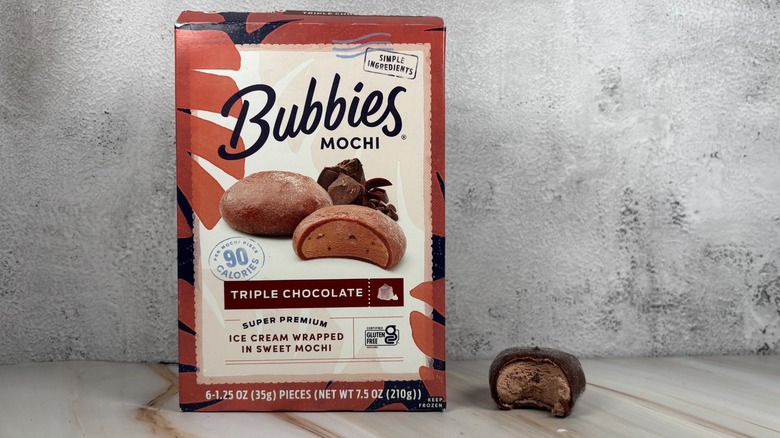 Bubbies Triple Chocolate mochi box next to mochi with bite taken out of it on table