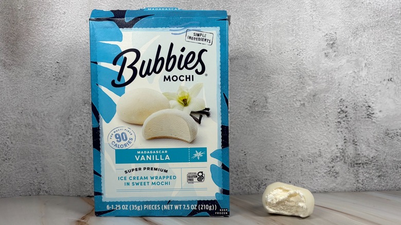 Bubbies Madagascar Vanilla mochi box next to mochi with bite taken out of it on table