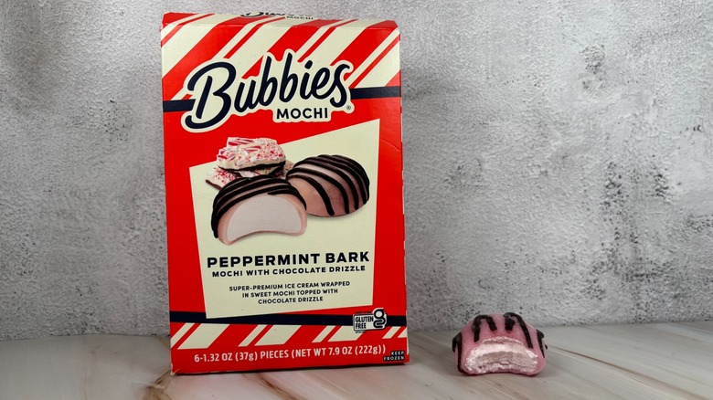 Bubbies Peppermint Bark mochi box next to mochi with bite taken out of it on table