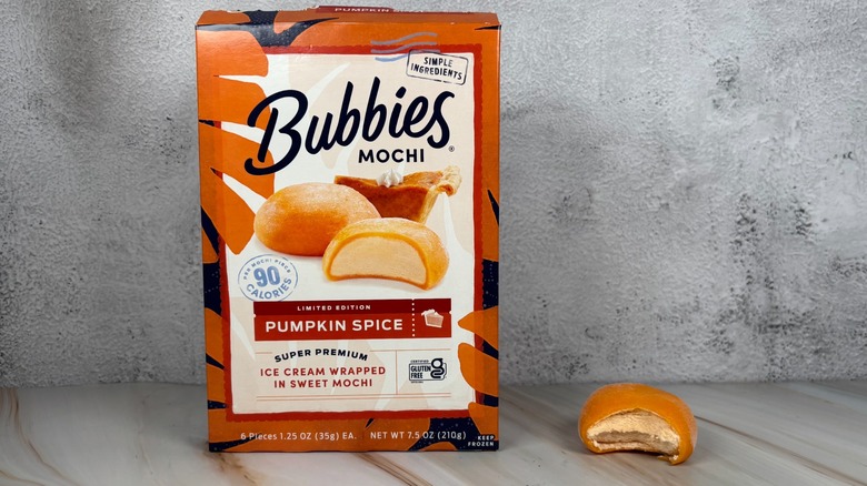 Bubbies Pumpkin Spice mochi box next to mochi with bite taken out of it on table