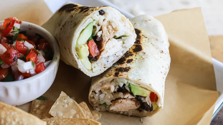 Ancho Chicken and Avocado Burrito on parchment paper with pico de gallo