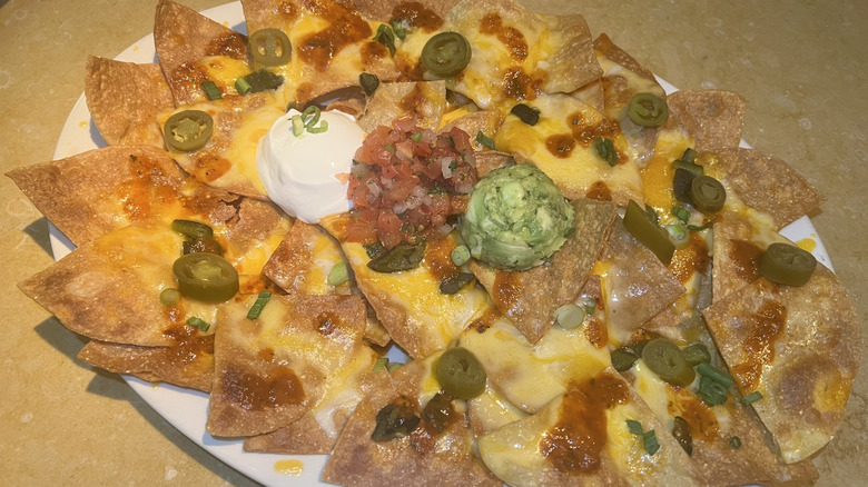 A plate of Factory Nachos with sour cream
