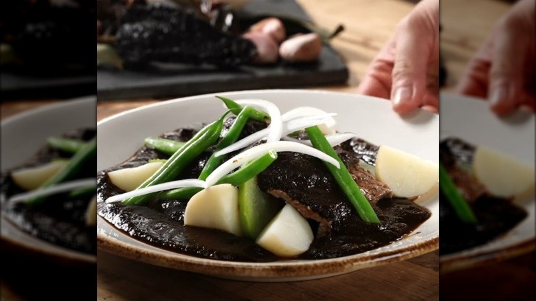 Plate of mole chichilo with beef, green beans, and potatoes