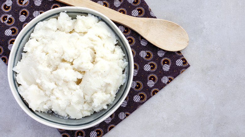 Traditional South African pap in bowl next to wooden spoon