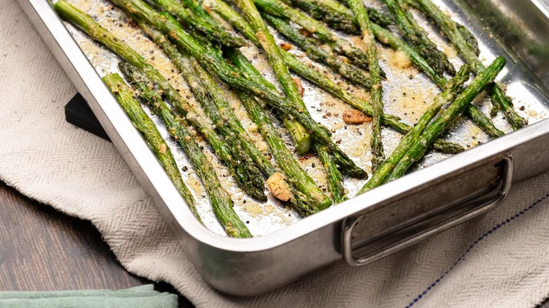 Roasting dish filled with roasted asparagus with garlic and parmesan
