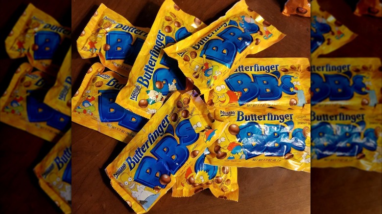 Packages of Butterfinger BB's on a wooden table.