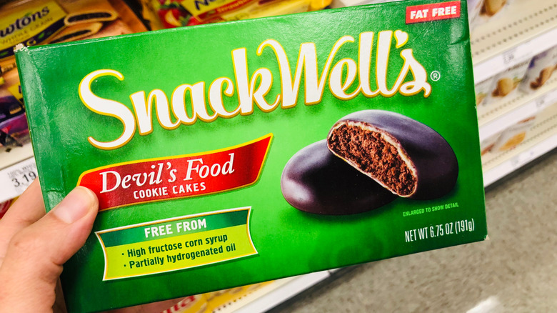 A hand holding package of SnackWell's Devil's Food Cookies.
