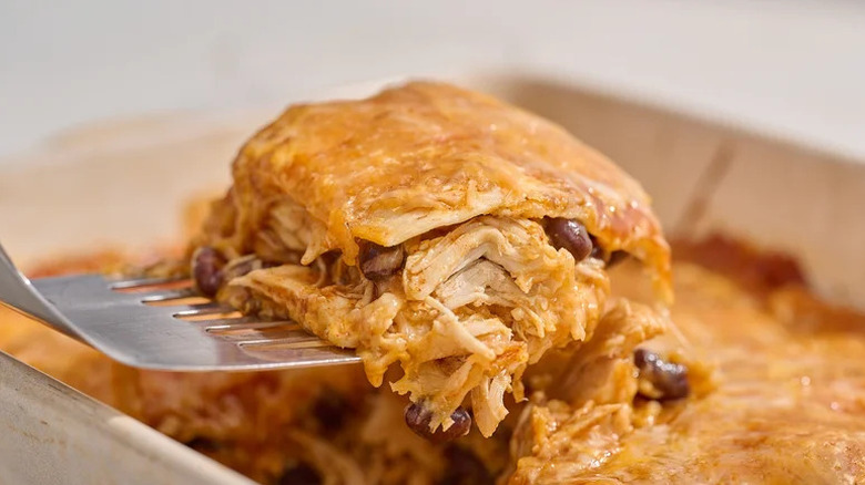 Square of Chicken Enchilada Casserole on spatula