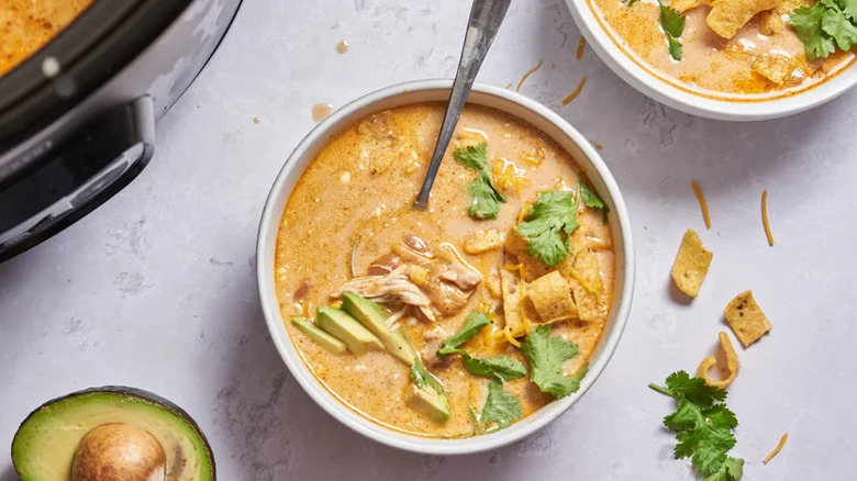 Slow Cooker Chicken Enchilada Soup in white bowl with cilantro