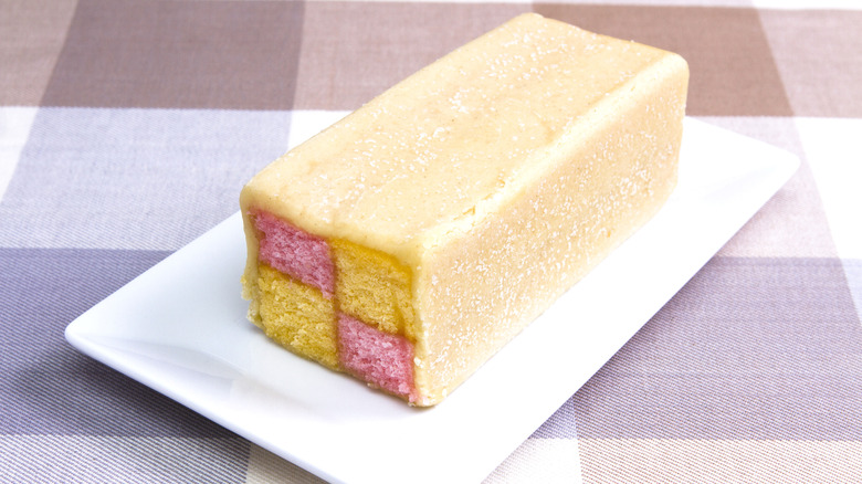 A battenberg cake shown on a rectangular plate, showcasing its famous pattern