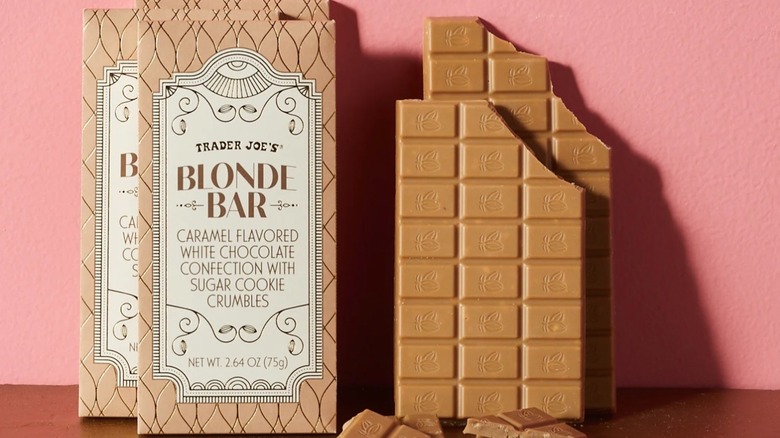 Wrapped Trader Joe's Blonde Bars next to unwrapped blonde bars on pink background