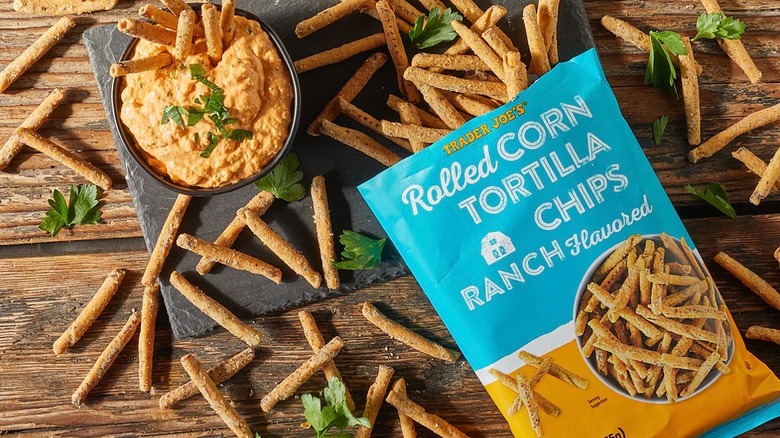 Trader Joe's Ranch Flavored Rolled Corn Tortilla Chips spilling out of bag onto black and wood surface